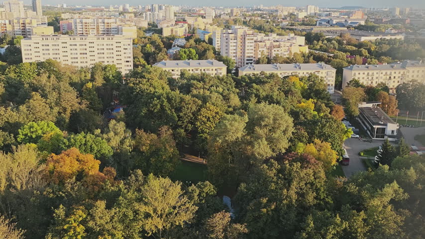Ferris wheel cabin offering an amazing aerial view of a city park with autumn foliage and residential buildings in the background