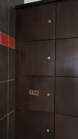 Mailboxes in an apartment building hallway with numbered wooden compartments, doors and locks in a residential interior