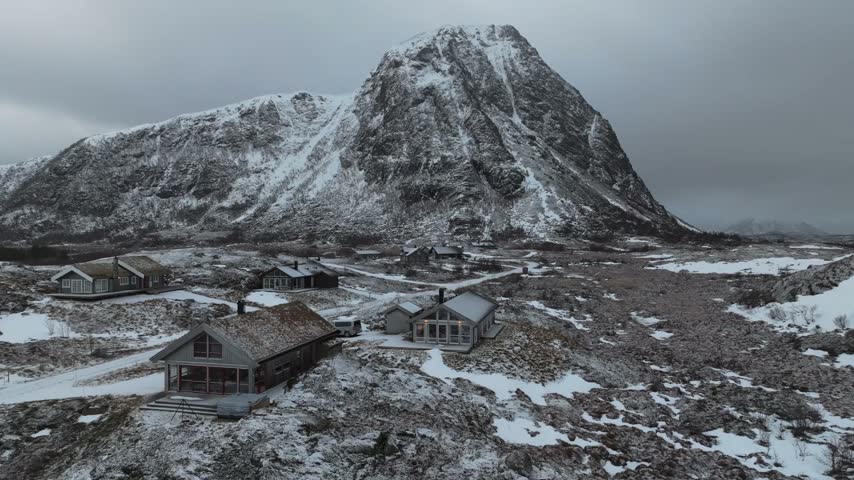 Aerial view of traditional cabins nestled in the snowy landscape of Lofoten in Vagan Municipality, Nordland, Norway.