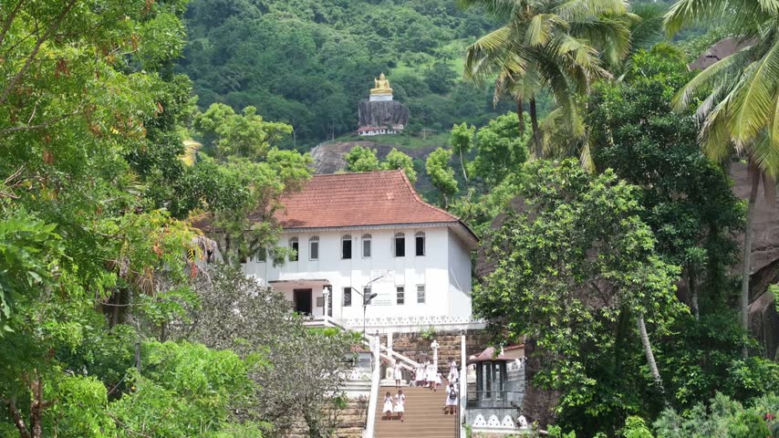 Aerial view of the Bahirawakanda Vihara Buddha Statue overlooking the white temple building surrounded by lush green trees and tropical vegetation in Kandy, Central Province, Sri Lanka.