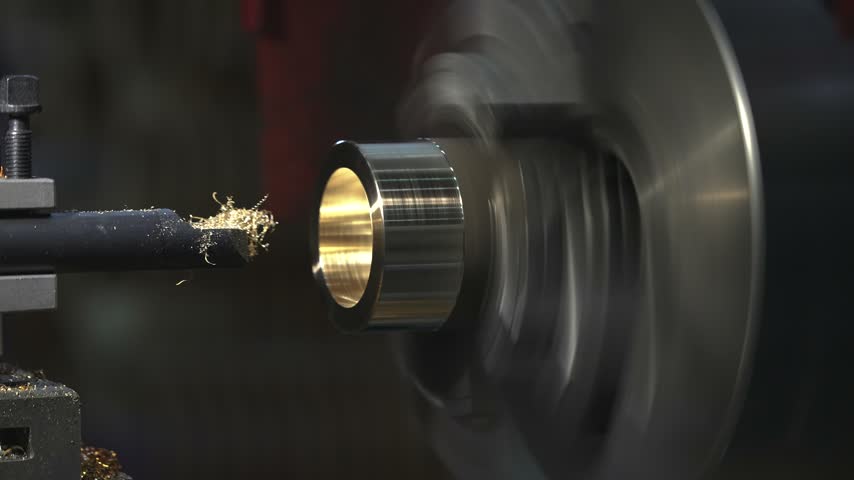 the process of manufacturing a metal part from a brass blank on a CNC lathe using drills and cutting tools