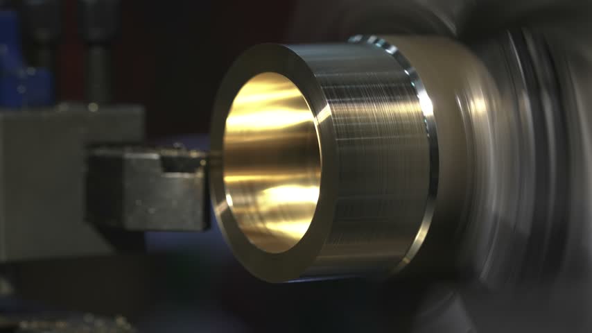 the process of manufacturing a metal part from a brass blank on a CNC lathe using drills and cutting tools