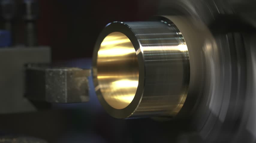 the process of manufacturing a metal part from a brass blank on a CNC lathe using drills and cutting tools