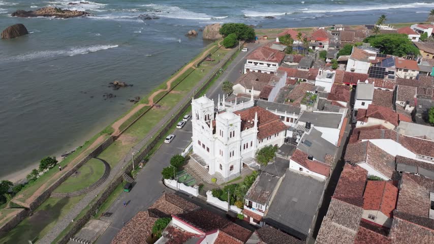 Aerial view of the historic Dutch Reformed Church surrounded by colonial rooftops and the ocean coastline in Galle, Southern Province, Sri Lanka.
