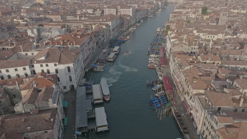 Aerial view of the Grand Canal with historic buildings, boats, and docks along the waterway in Venice, Veneto, Italy.
