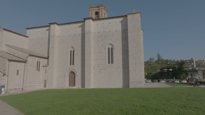Aerial view of the Basilica of San Domenico with its historic stone facade and surrounding green lawn in Perugia, Umbria, Italy.