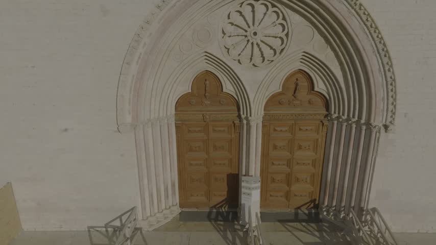 Aerial view of the ornate double-arched wooden entrance of the Basilica of Saint Francis in Assisi, Umbria, Italy.