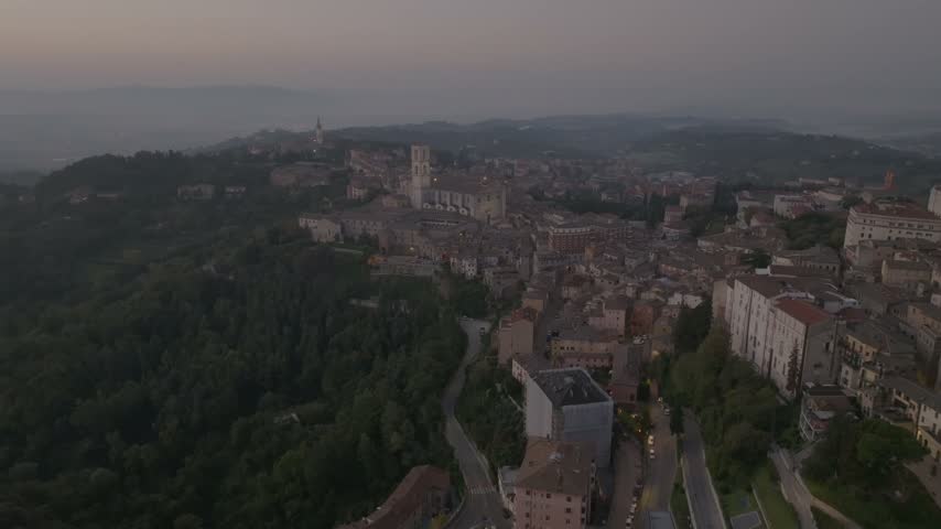 Aerial view of the historic city with its ancient rooftops, stone buildings, and narrow streets nestled in the hills of Perugia, Umbria, Italy.