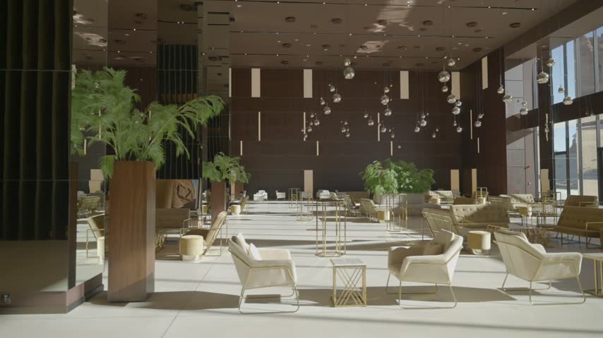 Wide view of a modern hotel lobby lounge area with comfortable seating and plants in AlUla