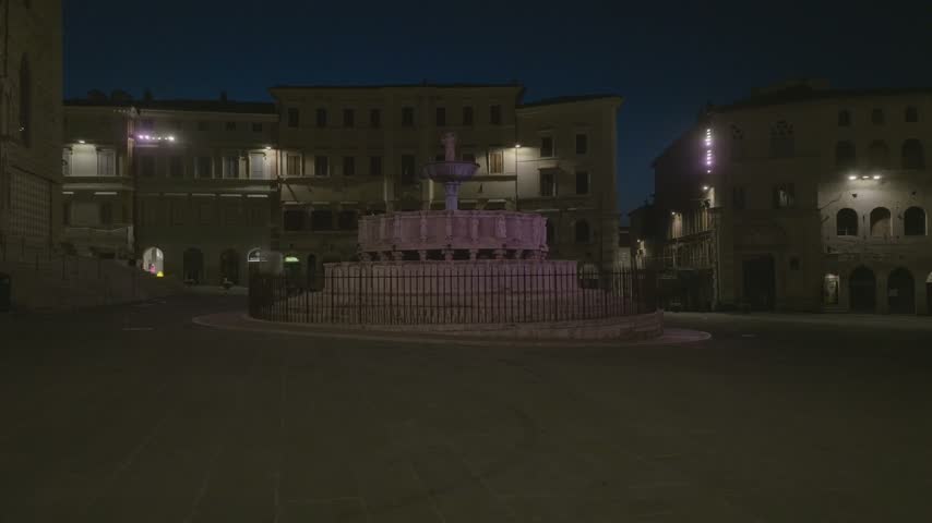 Aerial view of the historic Fontana Maggiore illuminated at night in the main square of Perugia, Umbria, Italy.