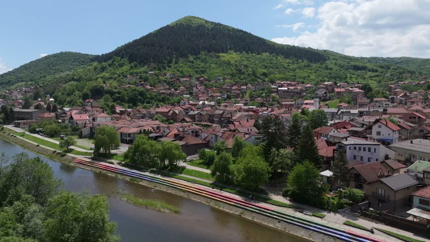 Aerial view of the town of Visoko with its pyramid-shaped hill, lush forests, and a river flowing through the urban landscape in Visoko, Federation of Bosnia, Bosnia and Herzegovina.
