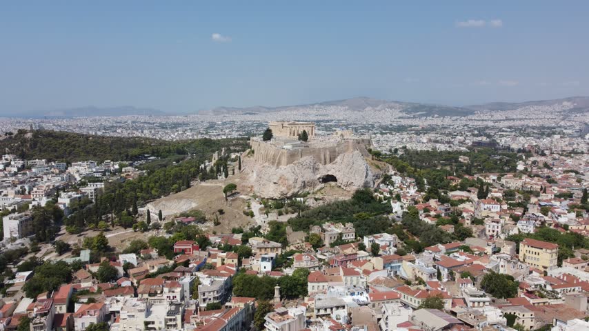 Aerial view of the ancient Acropolis of Athens, featuring historic temples and ruins overlooking the dense urban landscape of Athens, Attica, Greece.