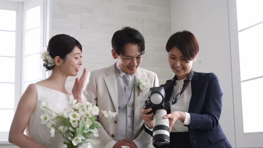Asian bride and groom talking with a wedding photographer