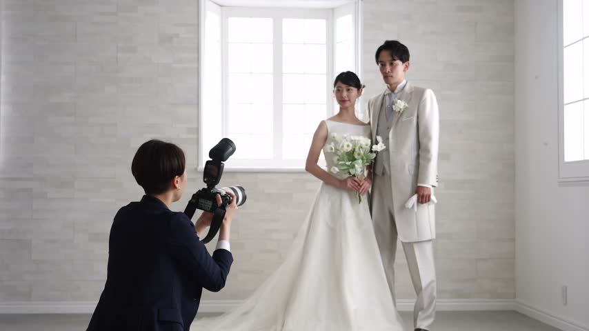 Asian photographer taking prewedding photos of a couple