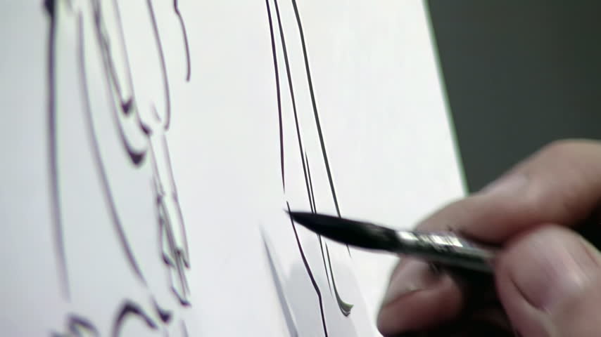 Artist Hand Holding Brush Drawing With Black Ink On Paper