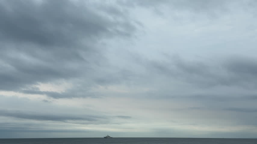 A Ship Sailing Beneath Flowing Clouds Over the Calm Sea
