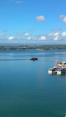 4K static shot from a cruise ship deck overlooking the harbor, water traffic, and coastal landscape during arrival and docking in San Juan, Puerto Rico.