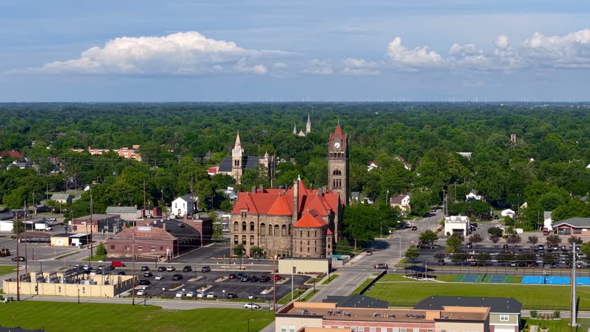 Aerial footage of Bay city hall  in Michigan, surrounded by lush green trees.