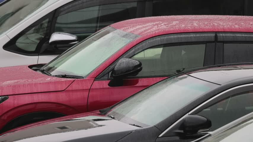Rain falling on cars parked in the parking lot