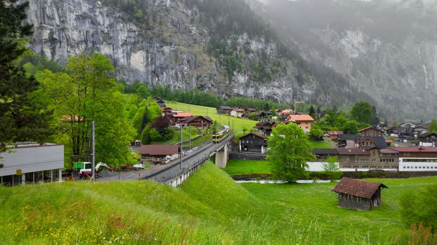 Scenic view of a traditional train crossing a bridge in an alpine village in Switzerland