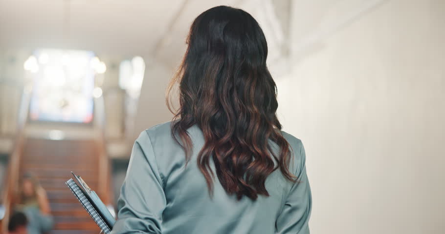 Woman, teacher and walking with books in university for exam preparation, test or learning syllabus. Female person, lecturer or tutor getting ready with textbooks for higher education curriculum