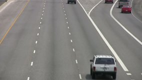 Video of vehicle, car and truck traffic driving away from view from overpass. High speed multiple lane freeway highway. San Antonio Texas. Don Despain of Rekindle Photo