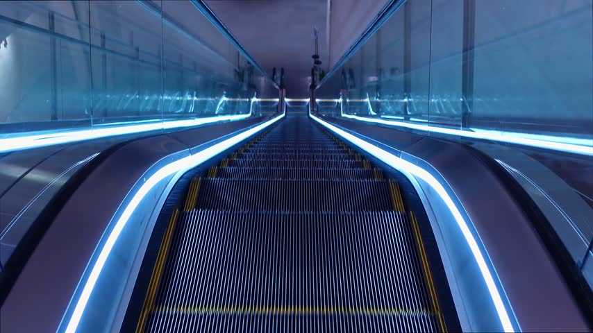 Modern escalator with glowing blue led lighting in empty shopping mall or office building interior moving staircase