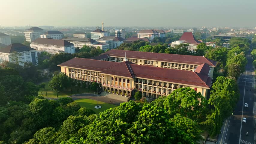 Aerial view of university campus buildings surrounded by lush tropical greenery