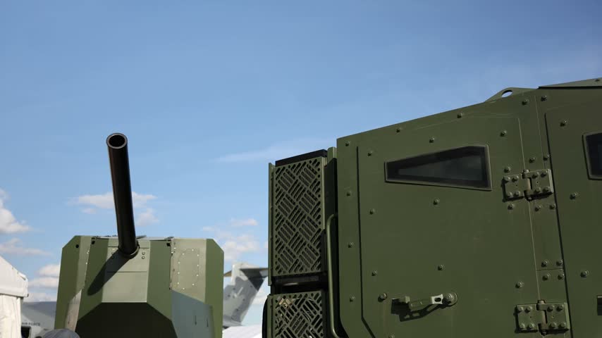 Armored military vehicle and artillery system displayed outdoors showing reinforced cabin protective armor and large caliber gun designed for modern battlefield operations