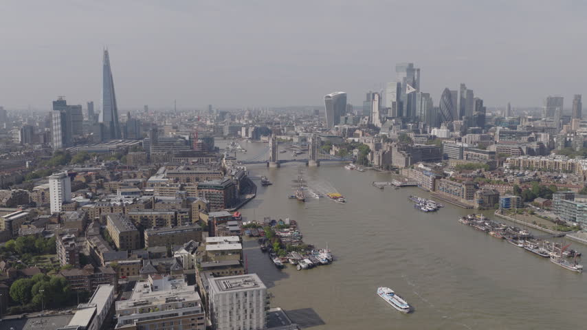 Establishing aerial view of London skyline featuring The Shard, Tower Bridge and the City of London. Iconic skyline of the capital of the United Kingdom