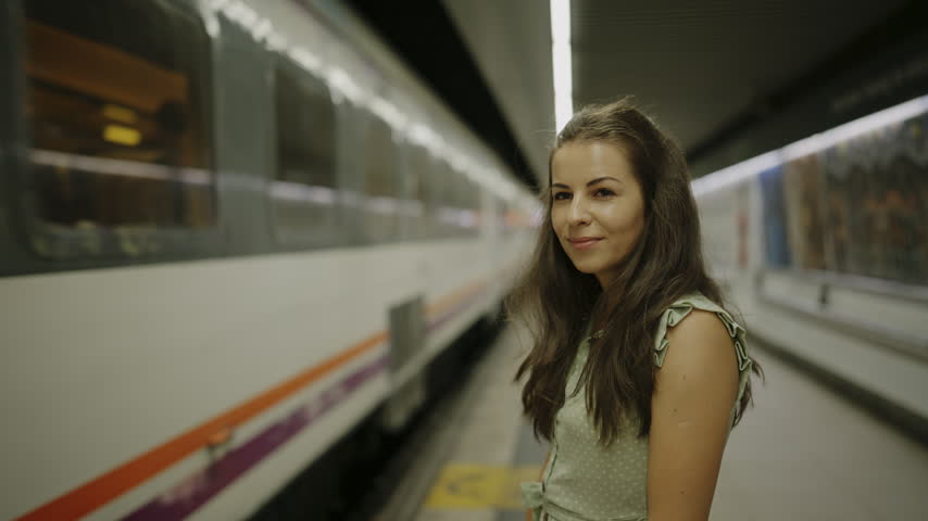 Female Tourist Waiting Beside Arriving Metro Train in Barcelona Subway Station