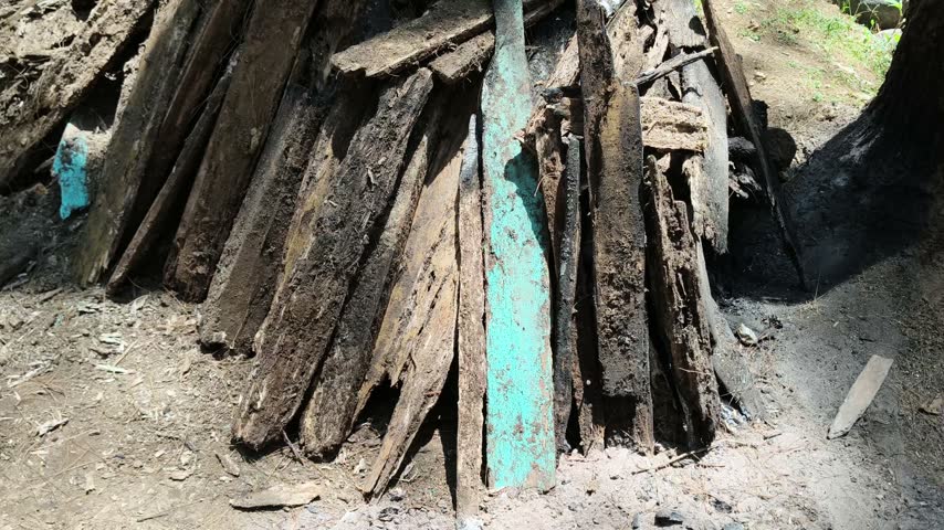 Stack of old weathered wooden boards on the ground outdoors