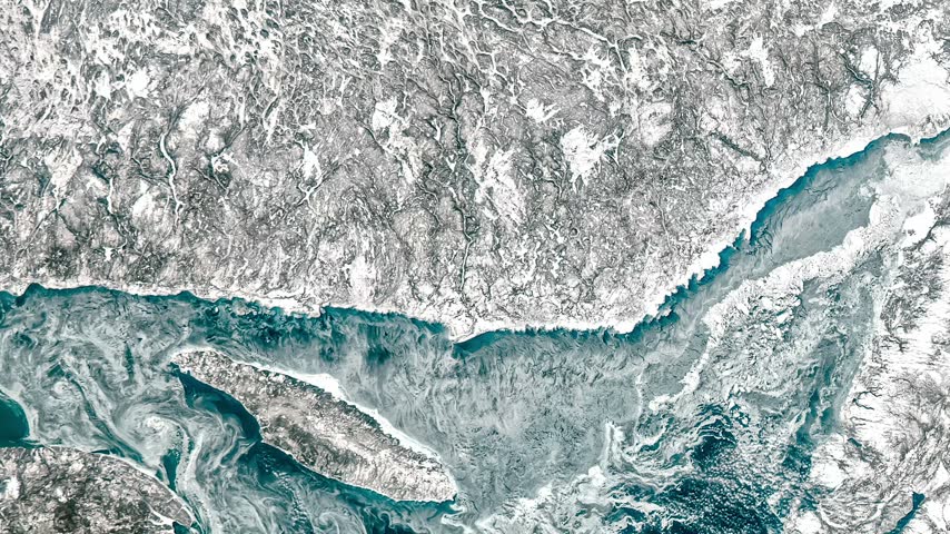 Top shot on north bay near snowy land. Camera is zooming out, rotating clockwise. Animation based on image by NASA