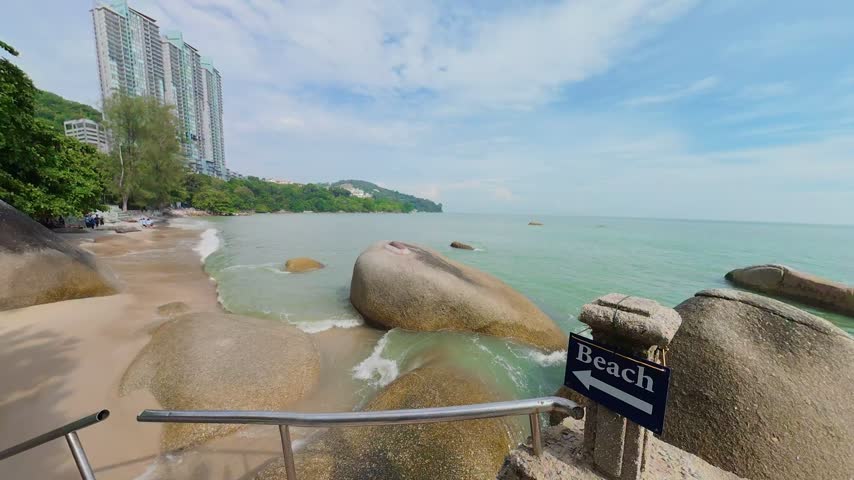 Dynamic Ocean Waves Splashing Over Coastal Rocks Beside Concrete Promenade Railing