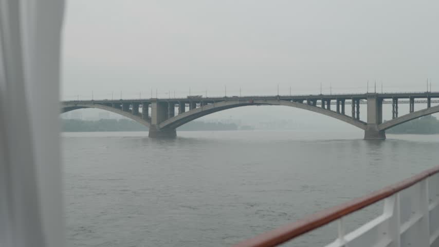 River and bridge viewed from ship deck on cloudy day