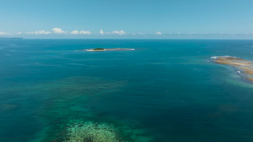 Tropical Islet with white sand in deep blue sea. Jobo Island in Surigao del Sur, Philippines.