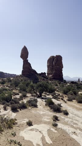 Vertical video of walking through Arches National Park in Utah, USA, surrounded by towering red sandstone formations and spectacular desert scenery