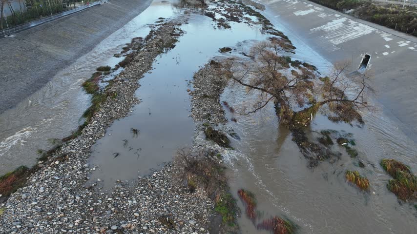 Aerial shot of flood damage and trash in the Los Angeles River after heavy rains.