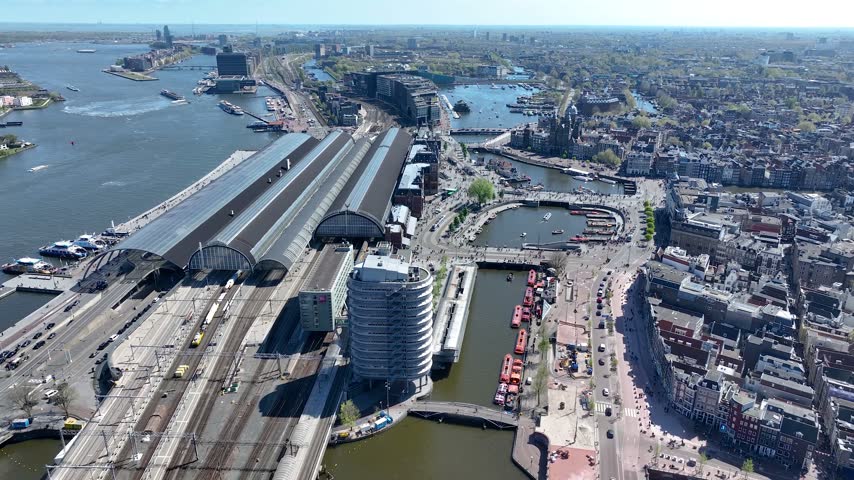 Aerial view of Amsterdam, Netherlands, showcasing historic buildings, canals, waterways and the vibrant cityscape, captured from above on a beautiful day.