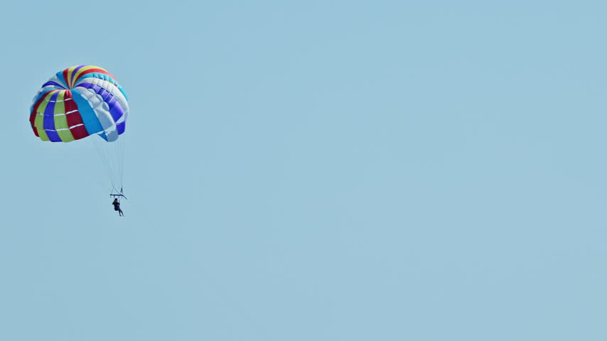 a man parasailing over the sea in barcelona