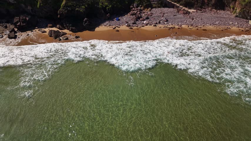  Turquoise ocean waves rolling on remote wild beach in Asturias Spain Playa de El Tranqueru 