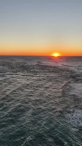 Rising sun over Pacific ocean horizon at Newcastle city of Australia Nobbys head.