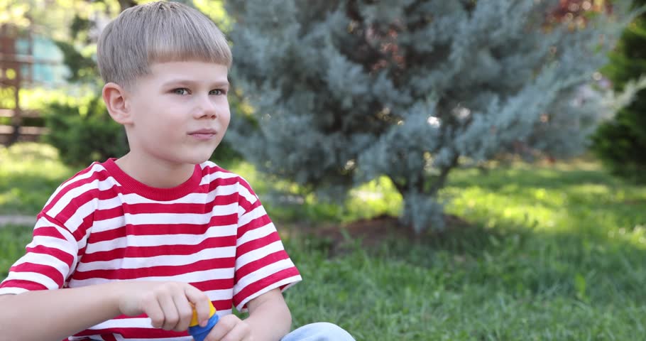Cute little boy blowing soap bubbles outdoors