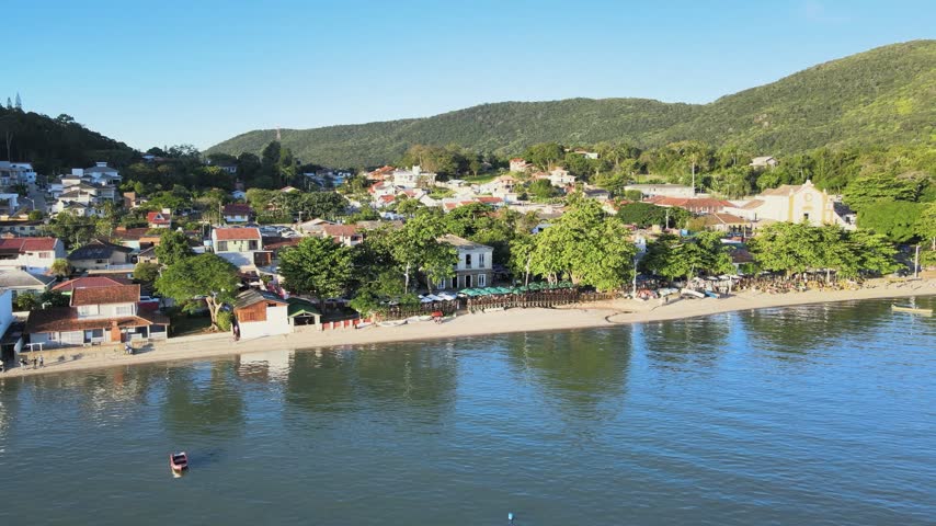 Aerial drone shot of the historic colonial mansion where Emperor Dom Pedro II stayed, located on the beautiful waterfront and beach of Santo Antonio de Lisboa village in Florianopolis, Brazil.
