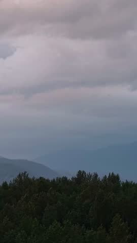 Majestic Mountain Landscape with Dense Forests Under Overcast Skies in British Columbia, Canada