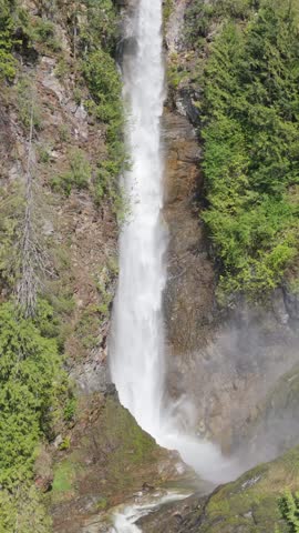 Majestic Waterfall Plunging Down Rocky Cliffs in Lush British Columbia, Canada