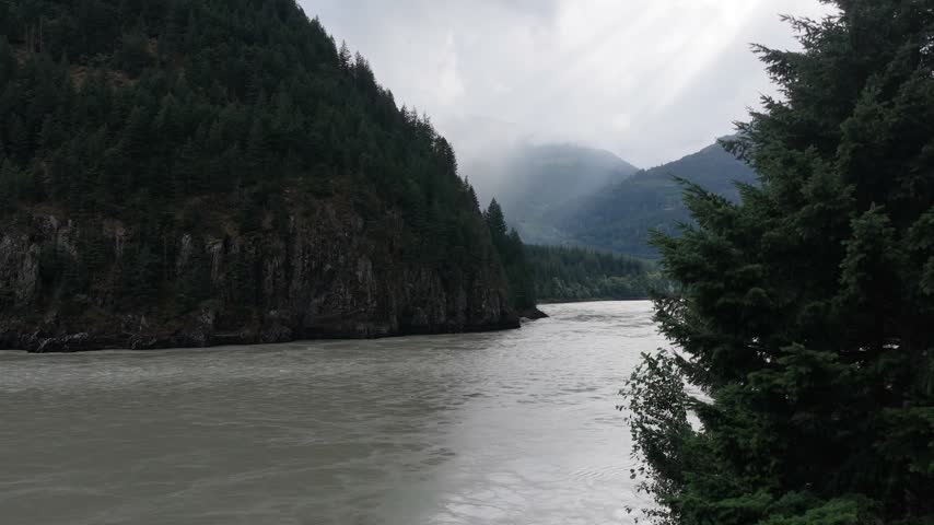 Scenic River Flowing Through Lush Green Forests and Majestic Mountains in British Columbia, Canada