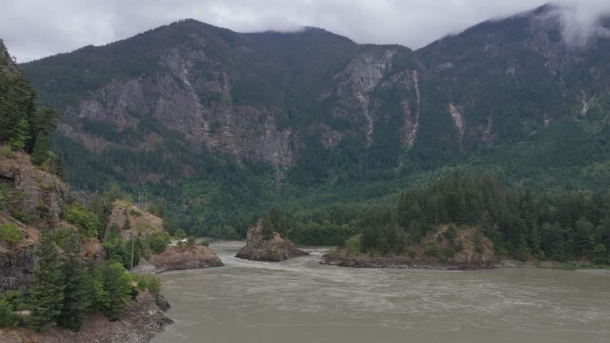 Majestic River Flowing Through Lush Forests and Towering Mountains in British Columbia, Canada