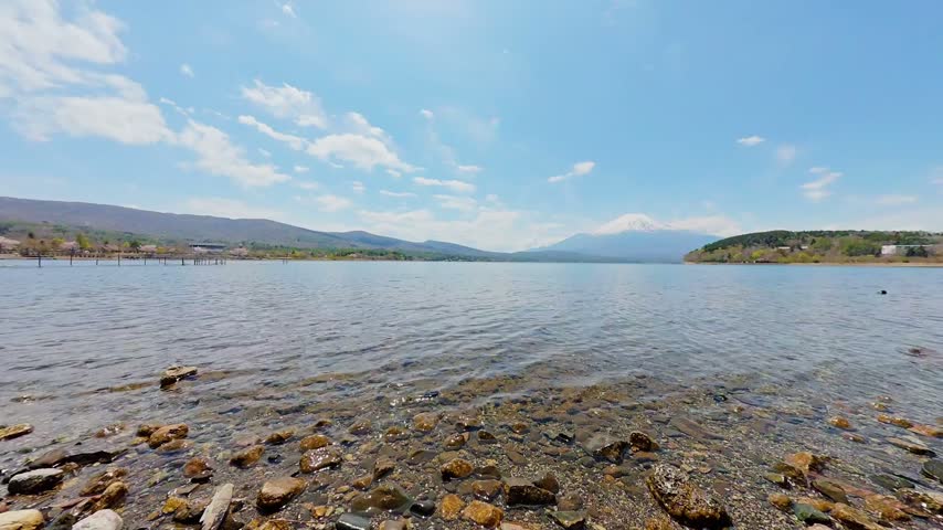 Rocky Shoreline of Lake Kawaguchiko Overlooking Mount Fuji Under Blue Sky