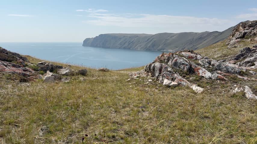 Video of coast of Lake Baikal. Top view of the Anga River mouth bay with rocky shores. Scenic lakeside landscape. Nature park